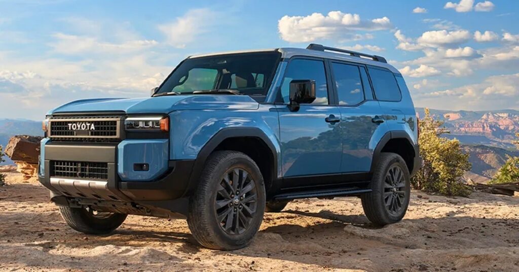 Blue 2024 Toyota Land Cruiser parked on a desert overlook, displaying its rugged exterior.