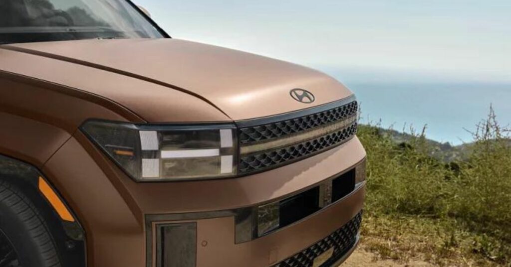 Close-up of the front of a brown SUV with distinctive headlight and grille design.